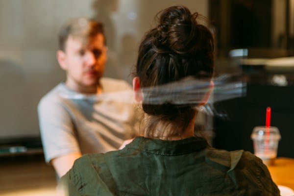 Two colleagues in conversation across a table in warm afternoon light.